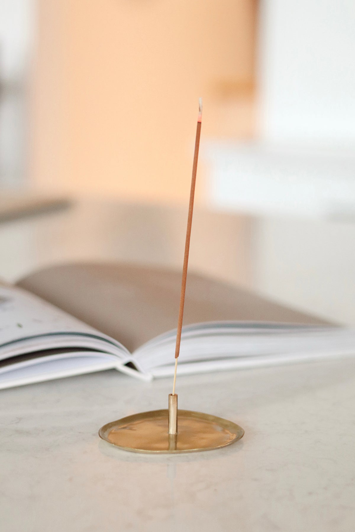 Incense stick on a small brass stand with a blurred background