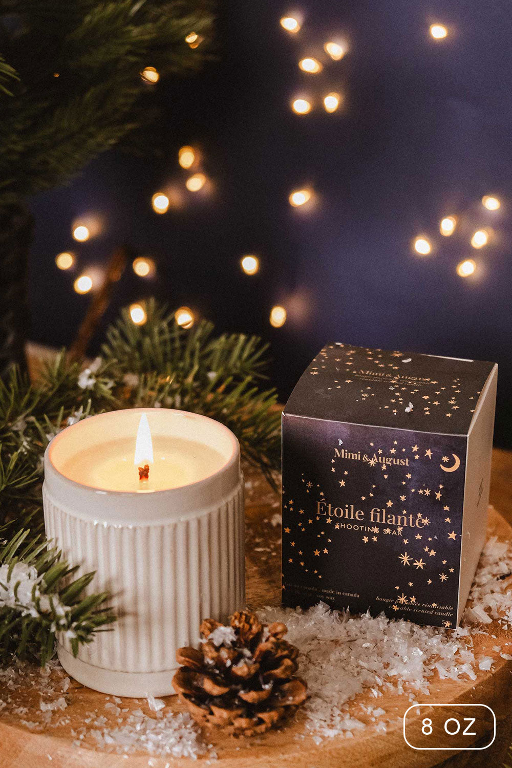 8 oz Shooting Star Christmas Candle by Mimi and August with a packaging on a wooden surface with decorative elements