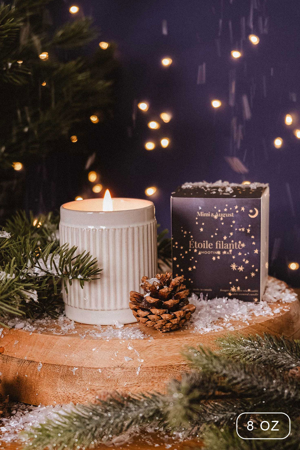 8 oz Shooting Star Christmas Candle by Mimi and August with a packaging on a wooden surface with decorative elements