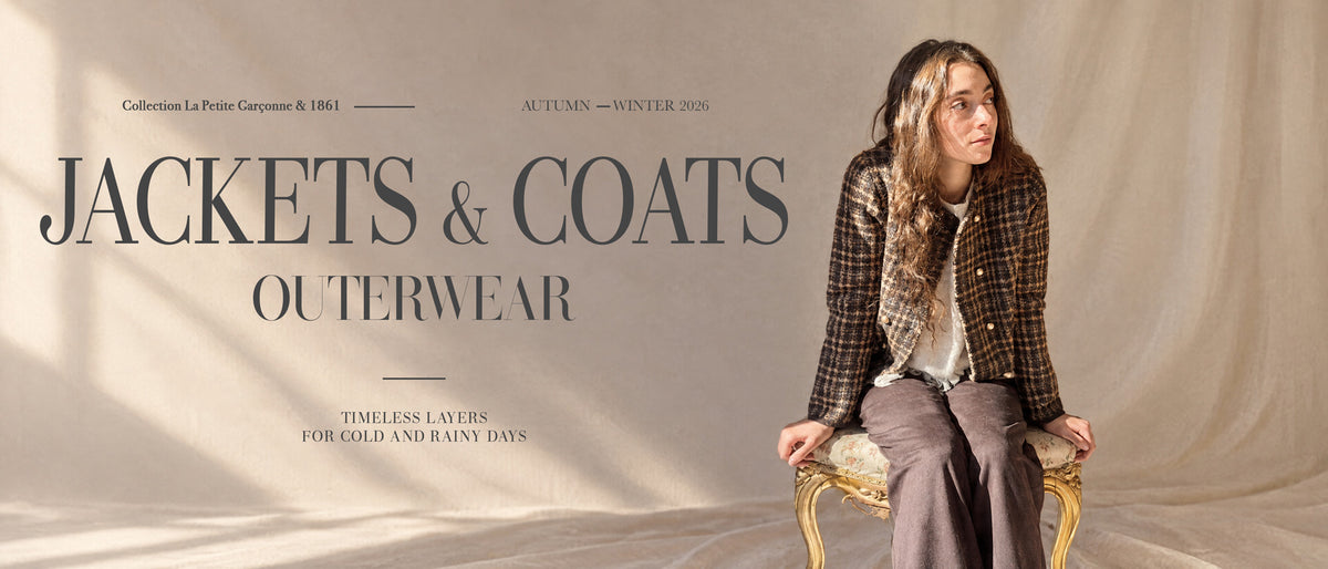 A fashion editorial-style product image showing a seated woman wearing a brown plaid jacket over a white top and gray pants, posed against a draped beige fabric backdrop. Large overlaid text reads 'JACKETS & COATS OUTERWEAR' with smaller collection and season text.