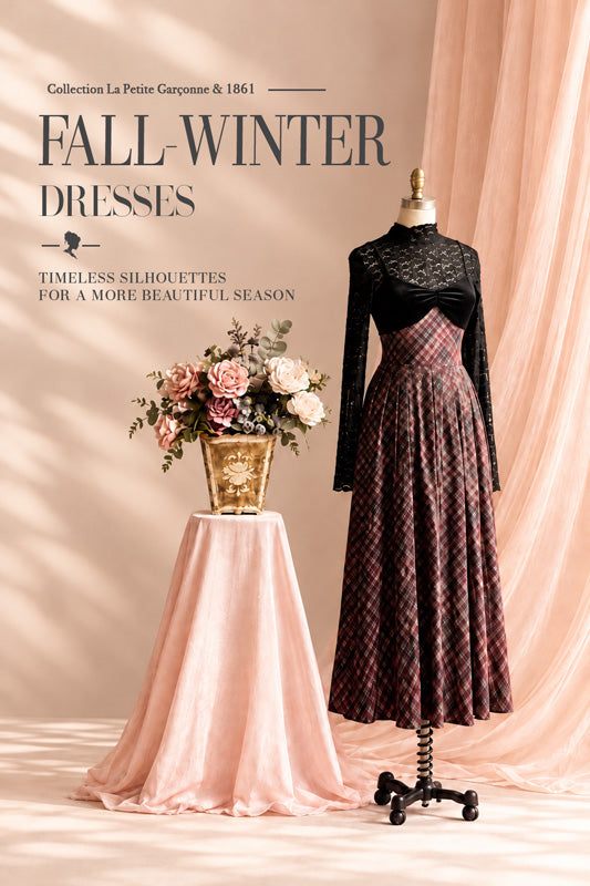A fashion editorial shot featuring a long-sleeve midi dress displayed on a mannequin, alongside a pink draped table with a floral arrangement. The background consists of warm beige drapery and soft shadows, with text reading 'FALL-WINTER DRESSES' and 'Collection La Petite Garçonne & 1861'.