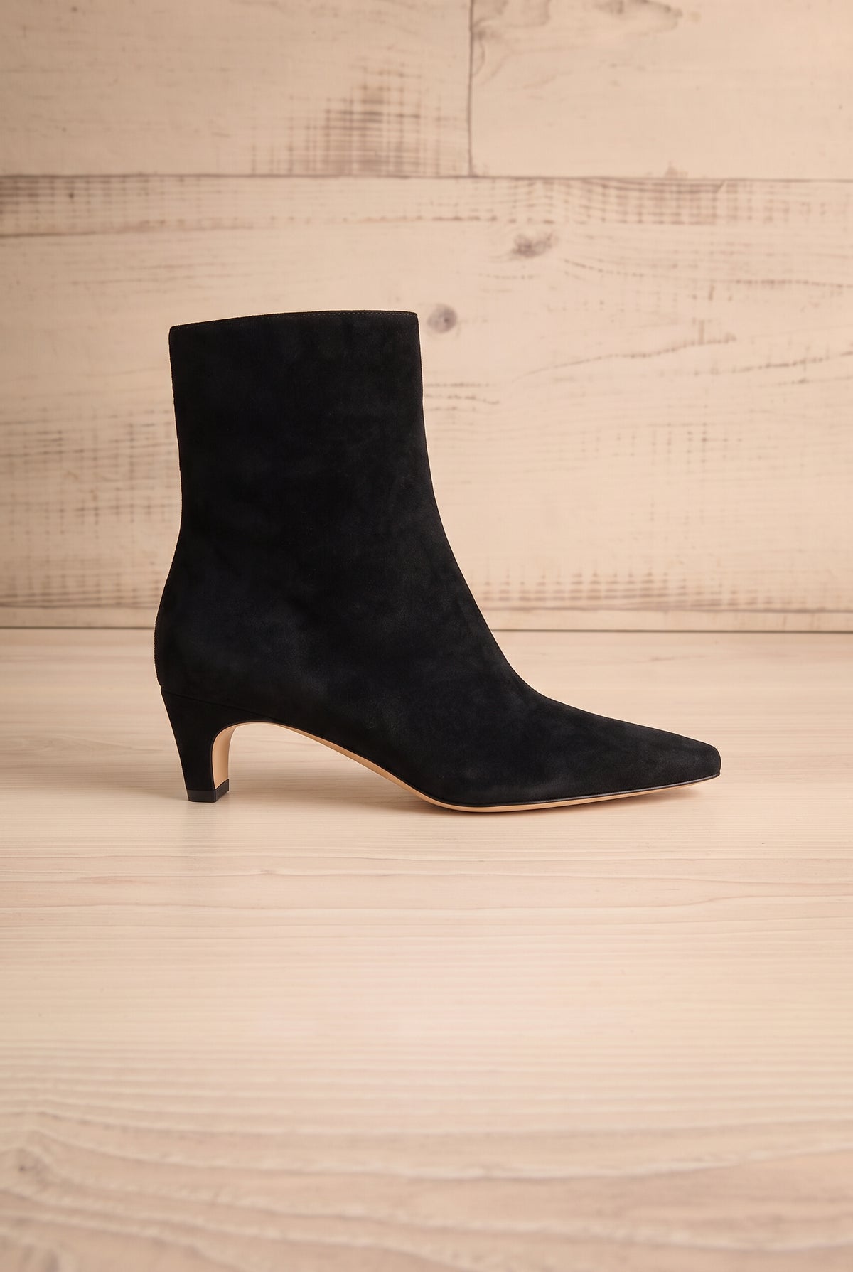 Side view of a single pointed-toe Bennet Black Leather Ankle Boot from Dolce Vita at la petite garçonne in Montreal