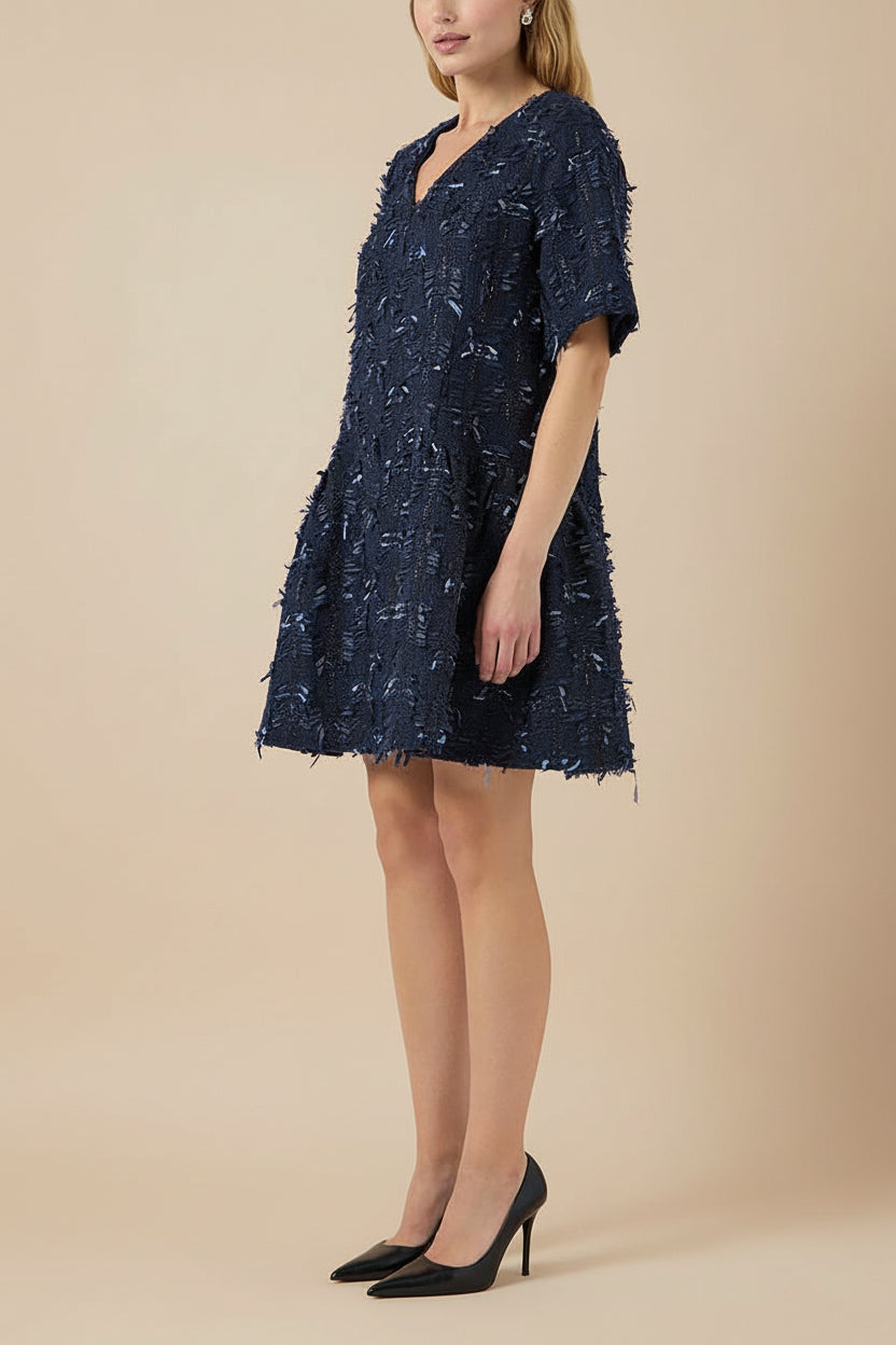 side view of a woman wearing Coralyne Navy Tweed V-Neck Mini Dress from Boutique 1861