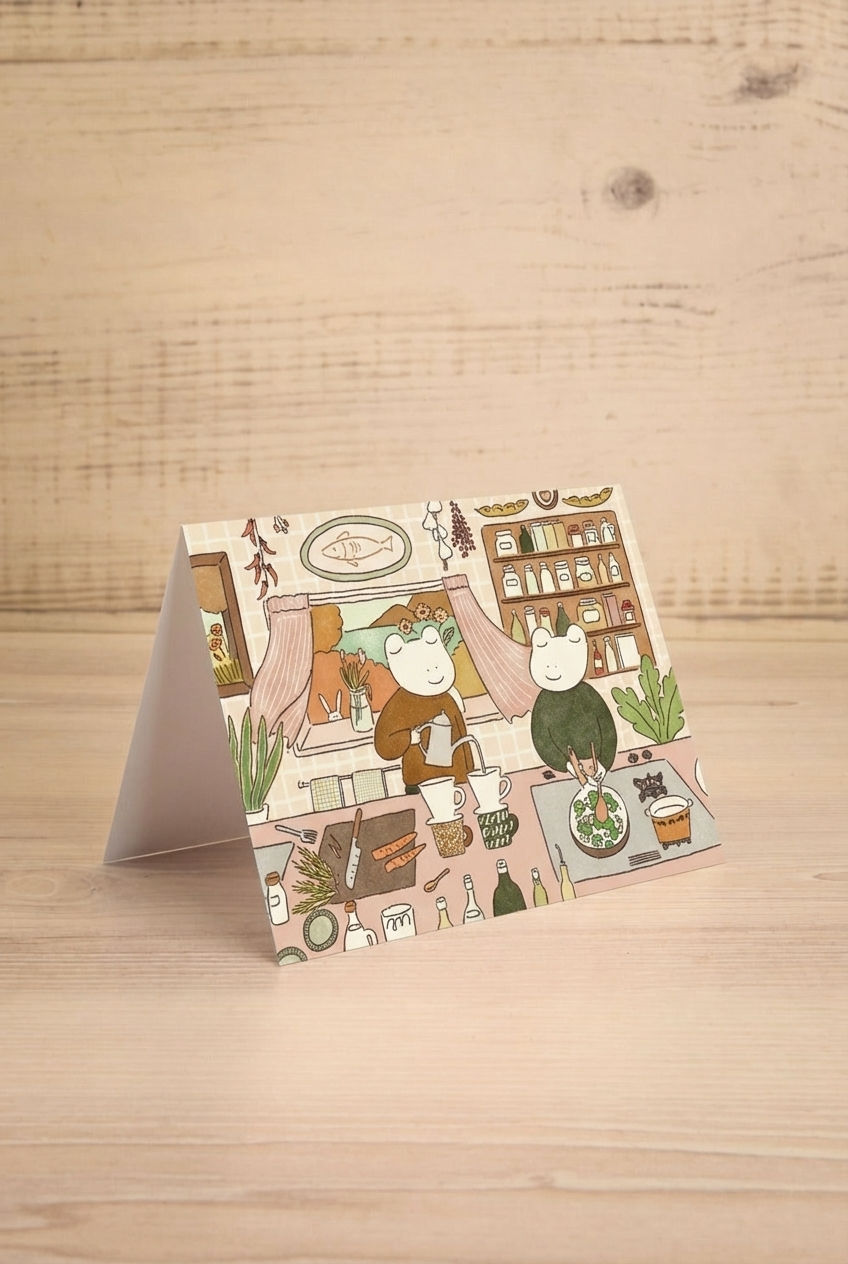 Greeting card with 2 frogs in a kitchen on a wooden surface