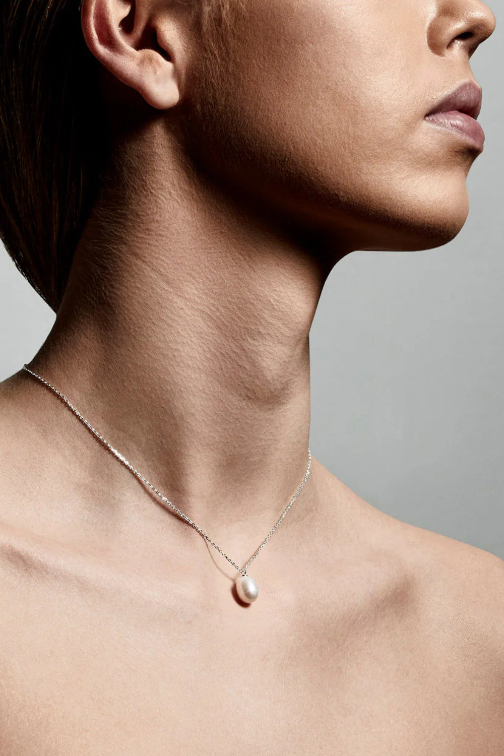 Woman wearing a Silver necklace with a pearl pendant from Pilgrim available at la petite garçonne