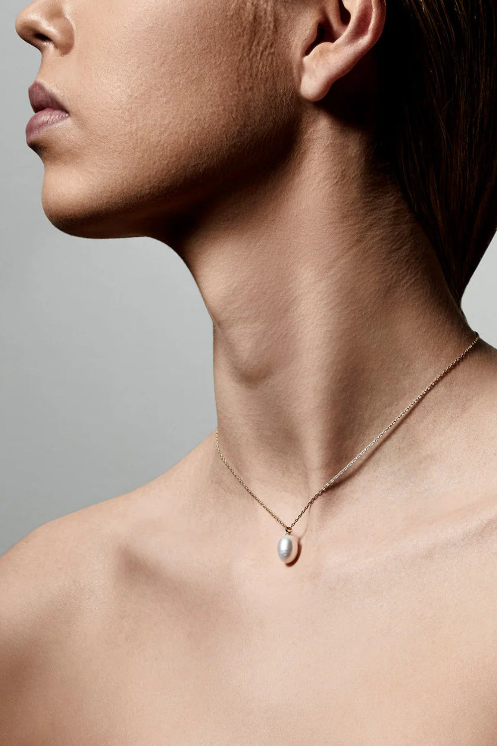 Woman wearing a Gold necklace with a pearl pendant from Pilgrim available at la petite garçonne