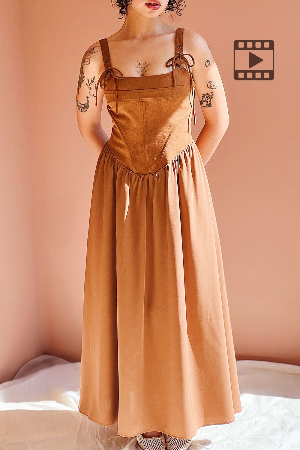 Photo of the Esma Caramel suede dress on a mannequin against a beige wall.