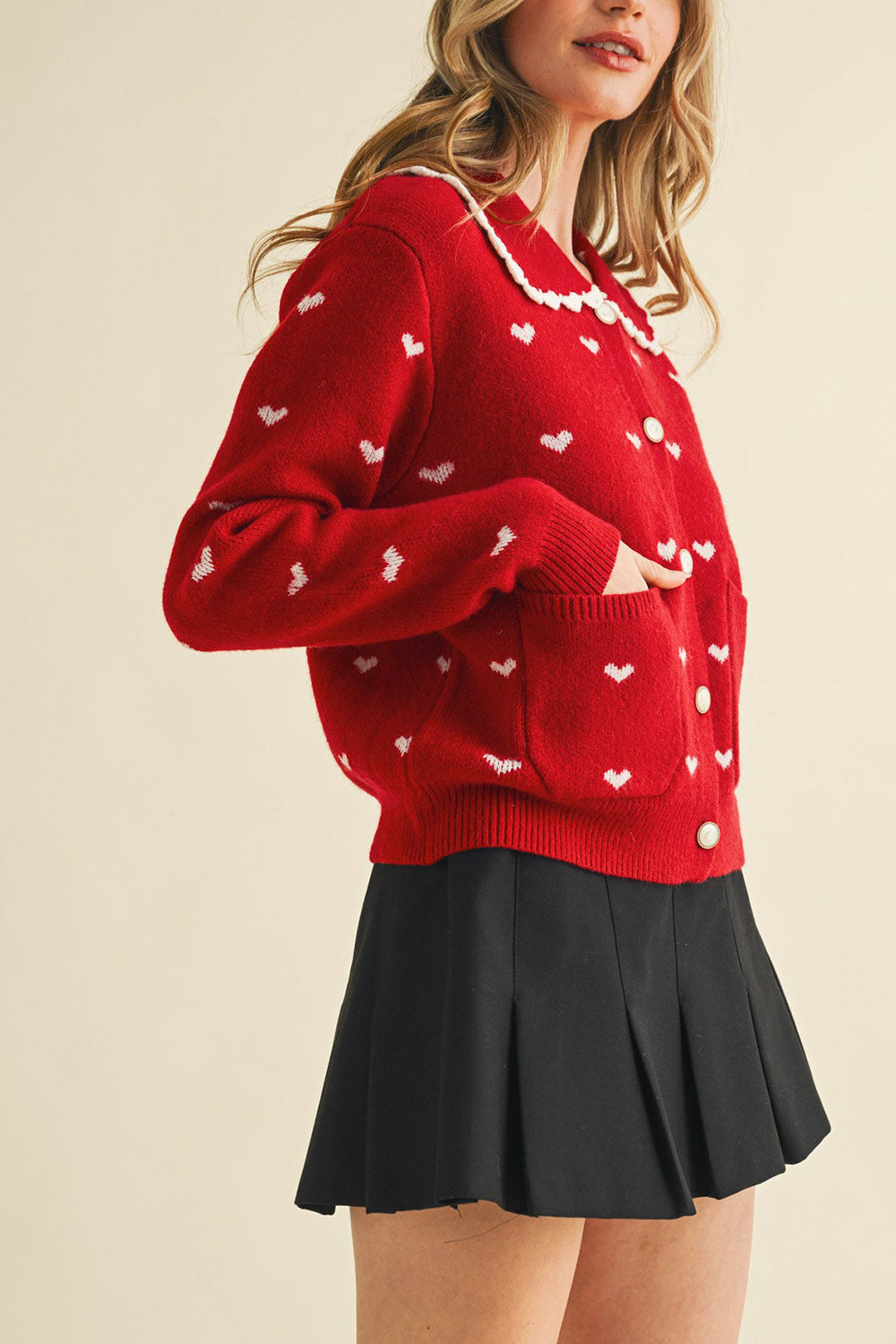 side view of a woman wearing Kristeen Red Knit Cardigan with Heart Pattern from Boutique 1861