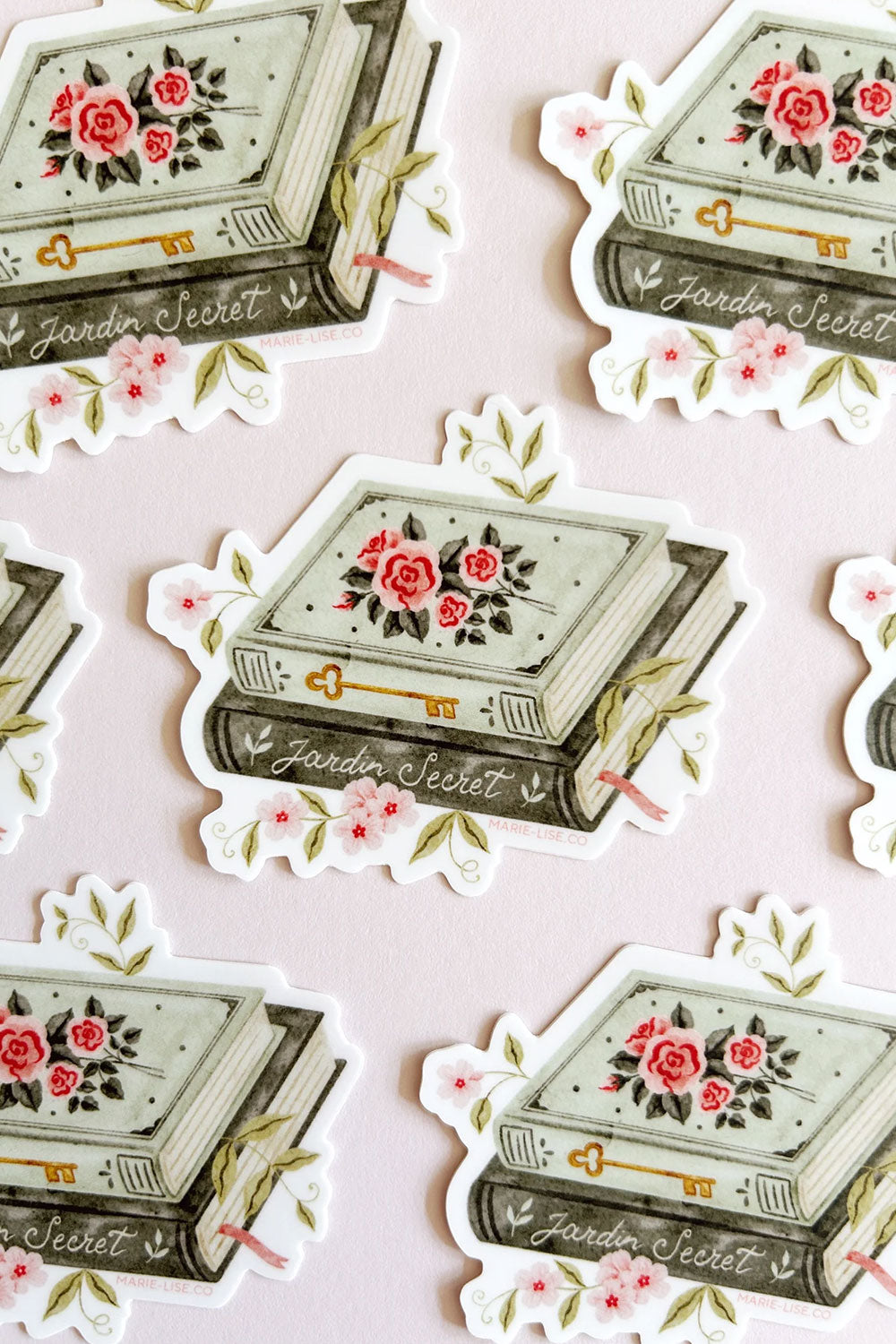 Decorative stickers with floral designs and 'Jardin Secret' text on a vintage book from Marie-Lise