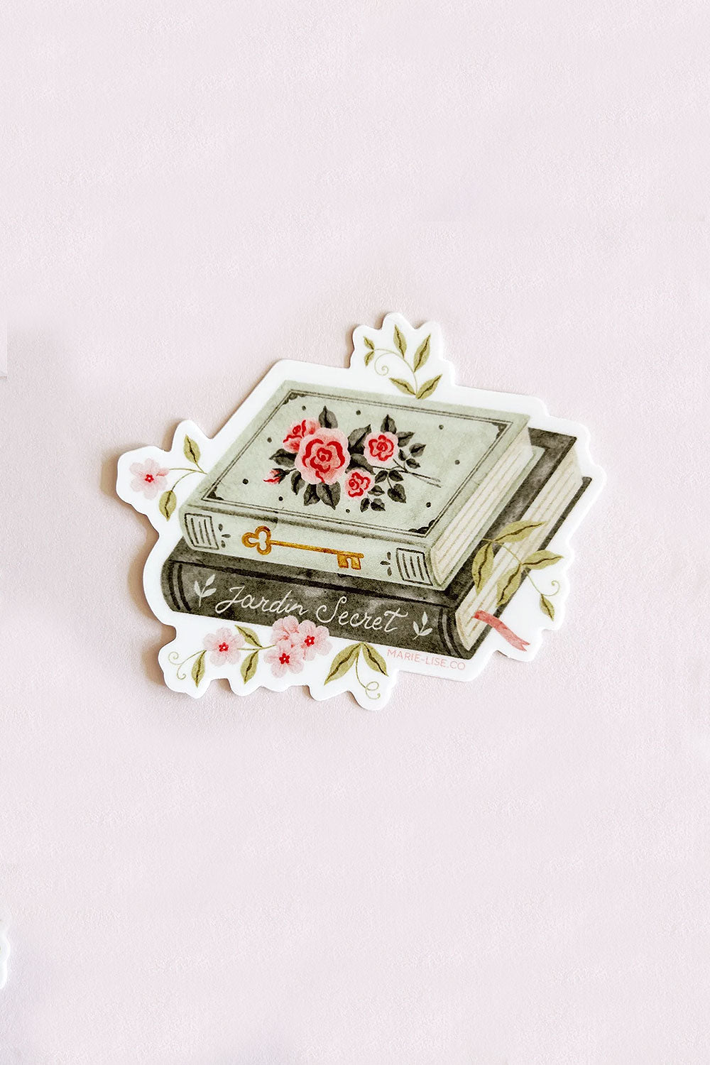 Decorative sticker with floral designs and 'Jardin Secret' text on a vintage book from Marie-Lise