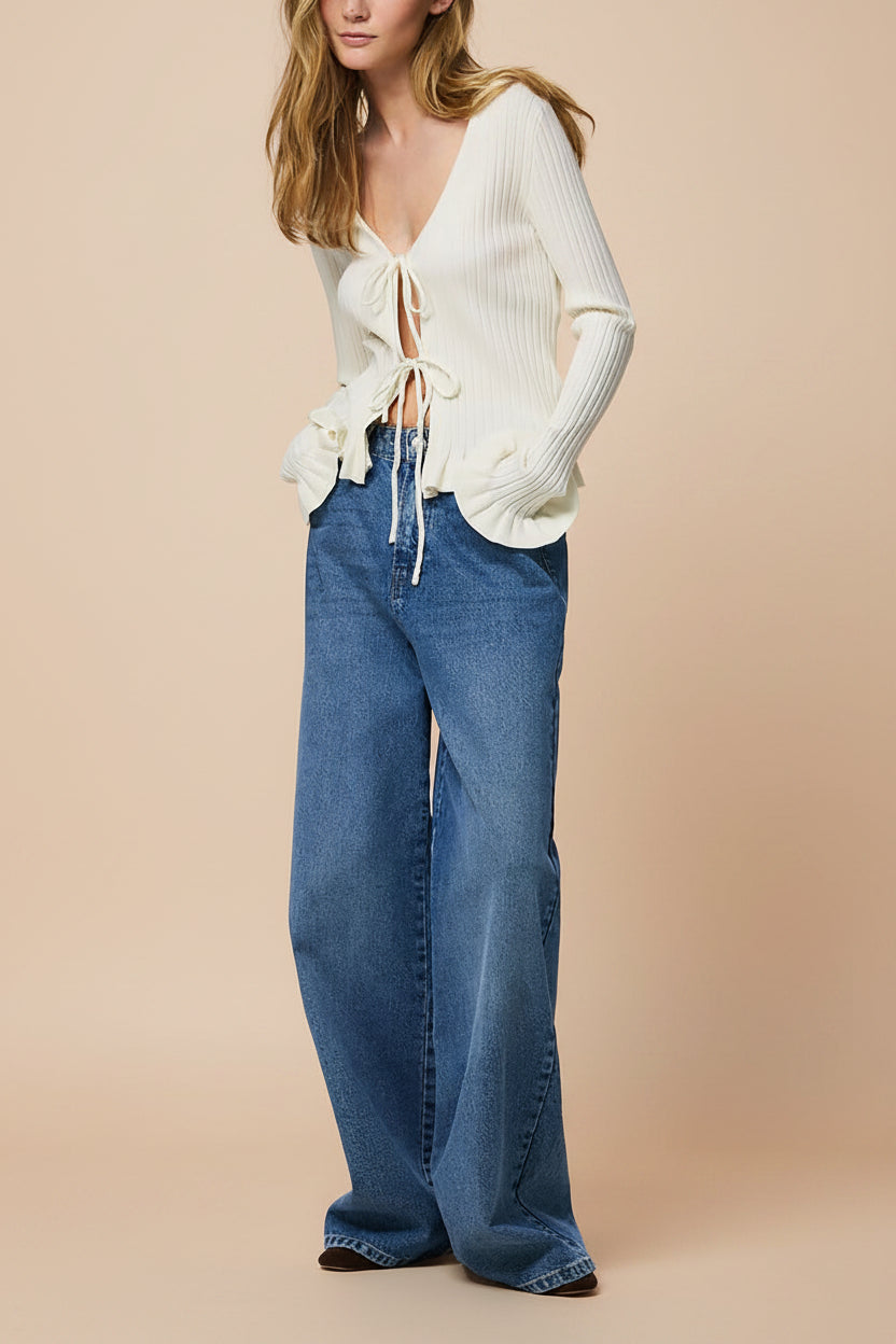 side of a woman wearing Lortona Ivory Ribbed Knit Cardigan with Front Tie and Frill Details from La petite garçonne