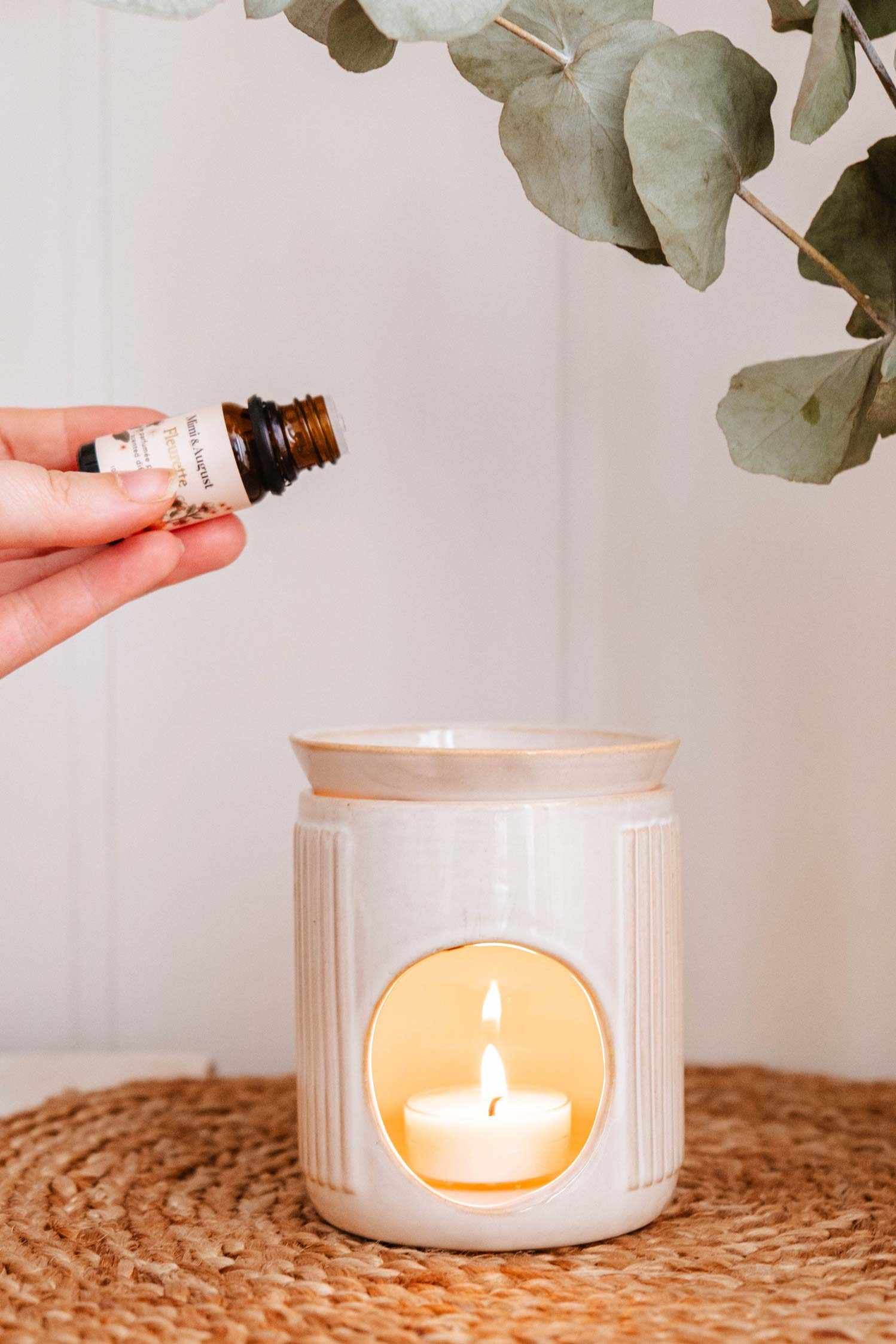 hand putting oil in Lueur Ceramic Diffuser at Maison garçonne