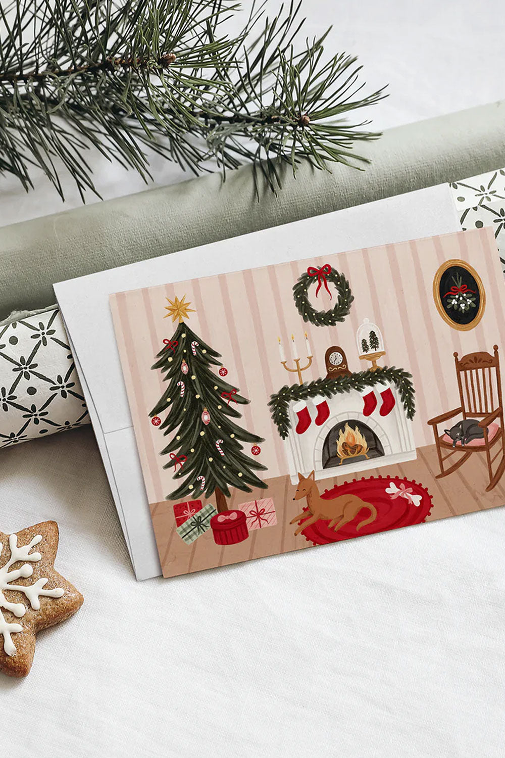 Christmas-themed greeting card with a fireplace, tree, and stockings from Marie-Lise illustration