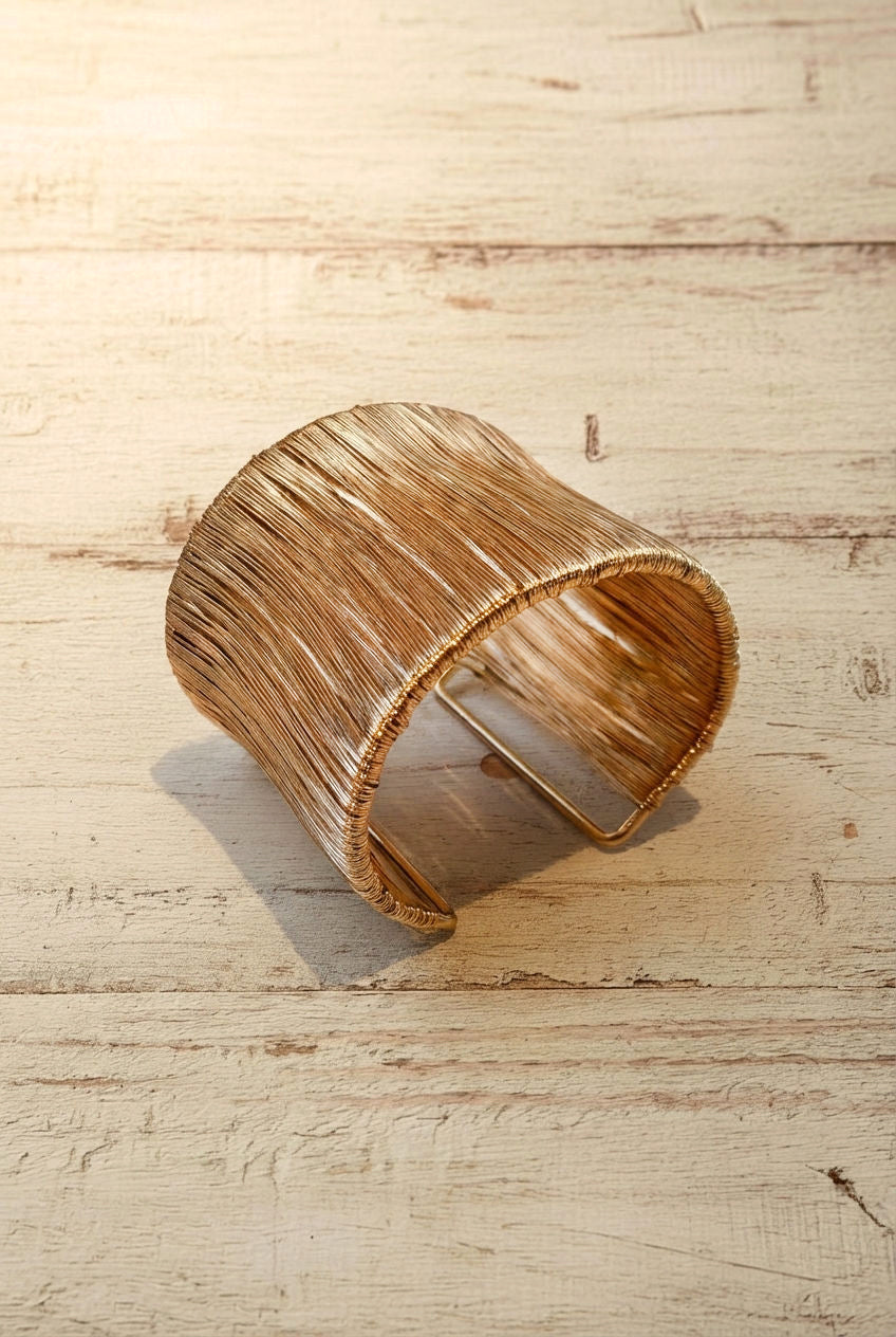 Gold bracelet Orbit on a light wood background