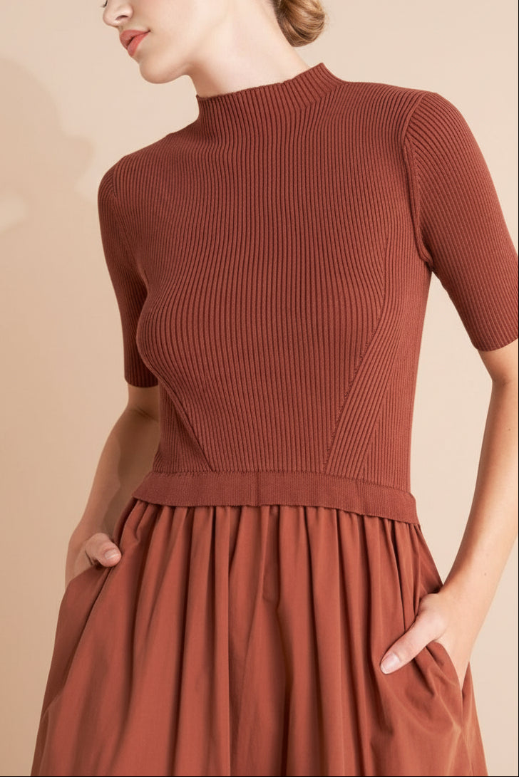 Close-up of a woman wearing the Penrith Rust Mock Neck Midi Dress from boutique 1861