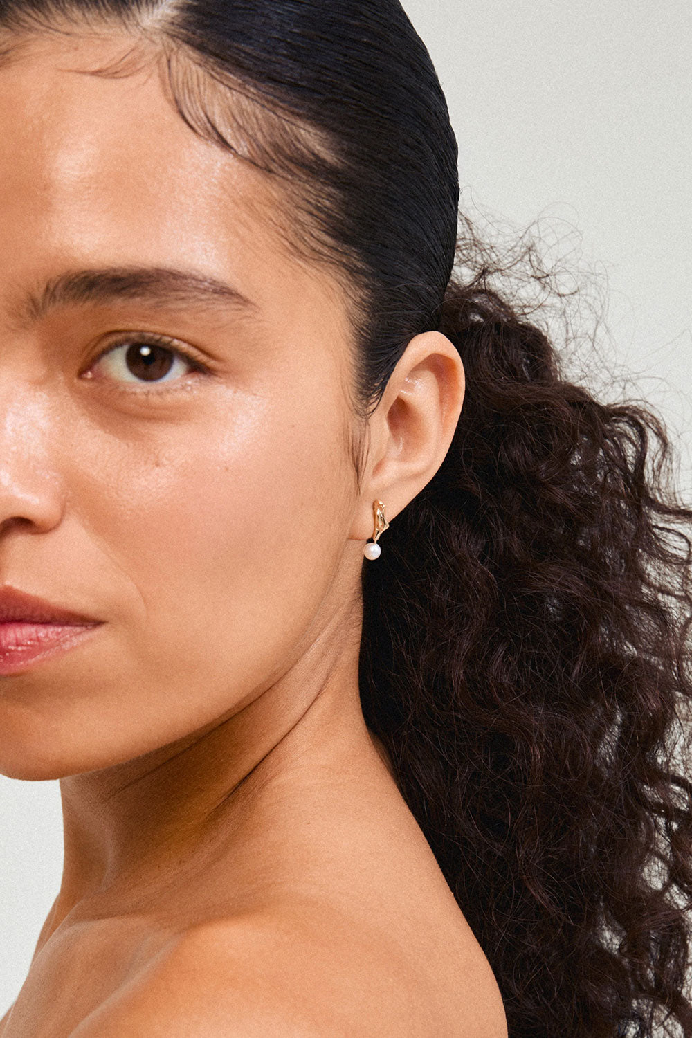 Photo of a woman wearing Bogor from Pilgrim, a gold earring with a pearl available in Montreal