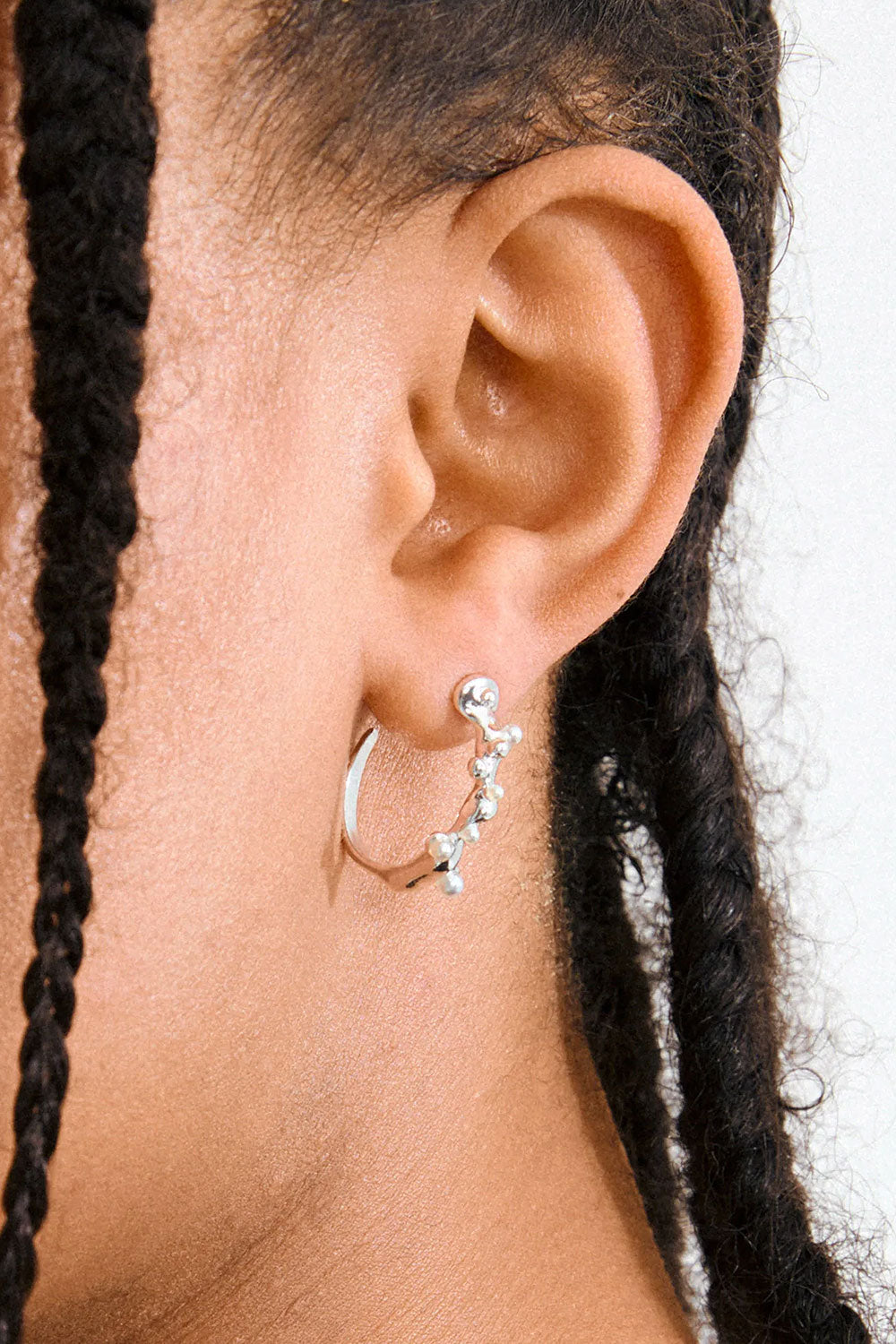 Close-up of a woman wearing Espoo by Pilgrim, a silver earring with a clear gemstone available at la petite garçonne in Montreal