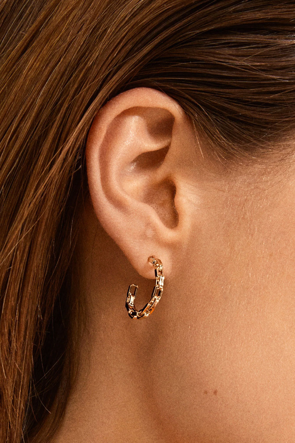 Close-up of a person wearing gold hoop earrings Lumbini from Pilgrim available at la petite garçonne in Montreal