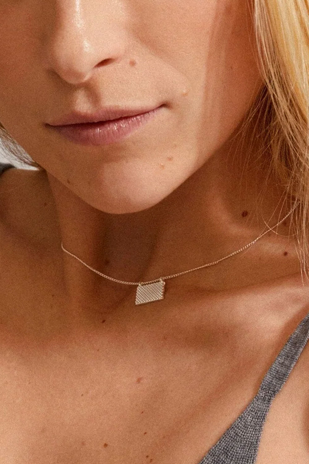 Close-up of a person wearing Pulse by Pilgrim, a delicate gold necklace with a geometric pendant available at la petite garçonne in Montreal