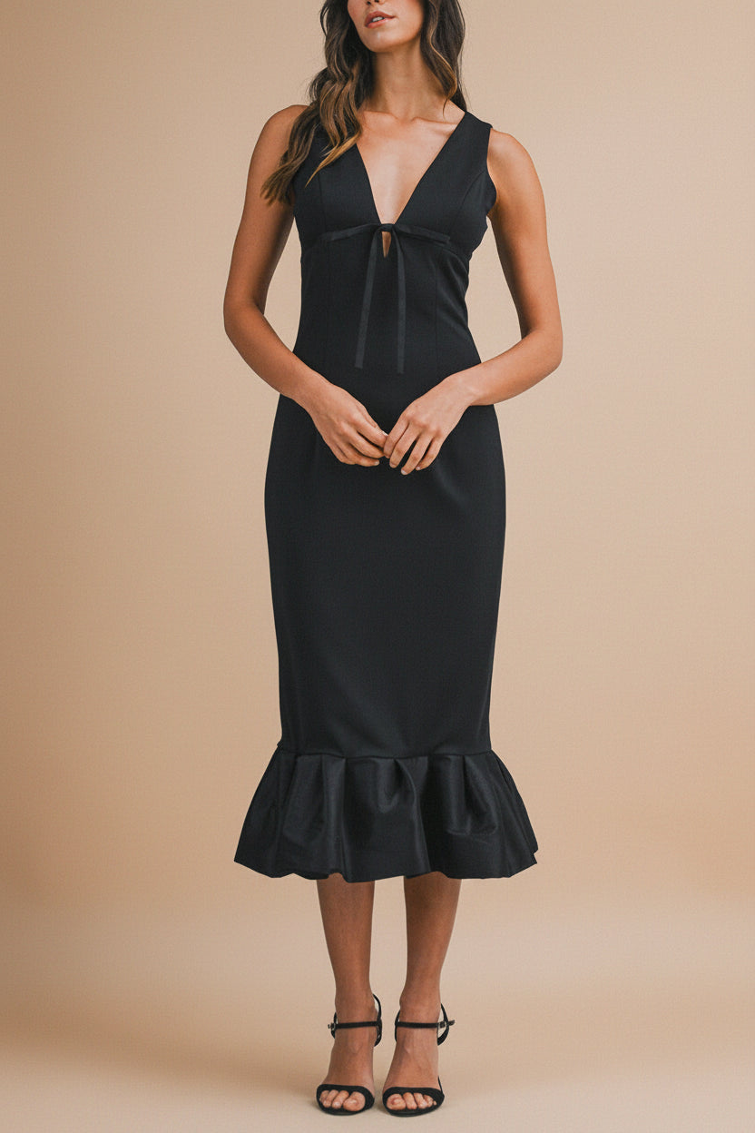 front of a woman wearing Soukaina Black V Neck Midi Dress with Bow Detail and Ruffle Hem from Boutique 1861