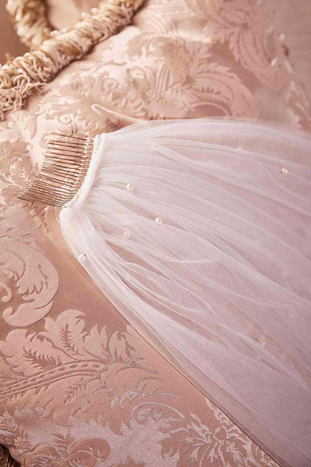 flat lay of a woman wearing Trisha Royal Length White Veil with Pearls from Boudoir 1861