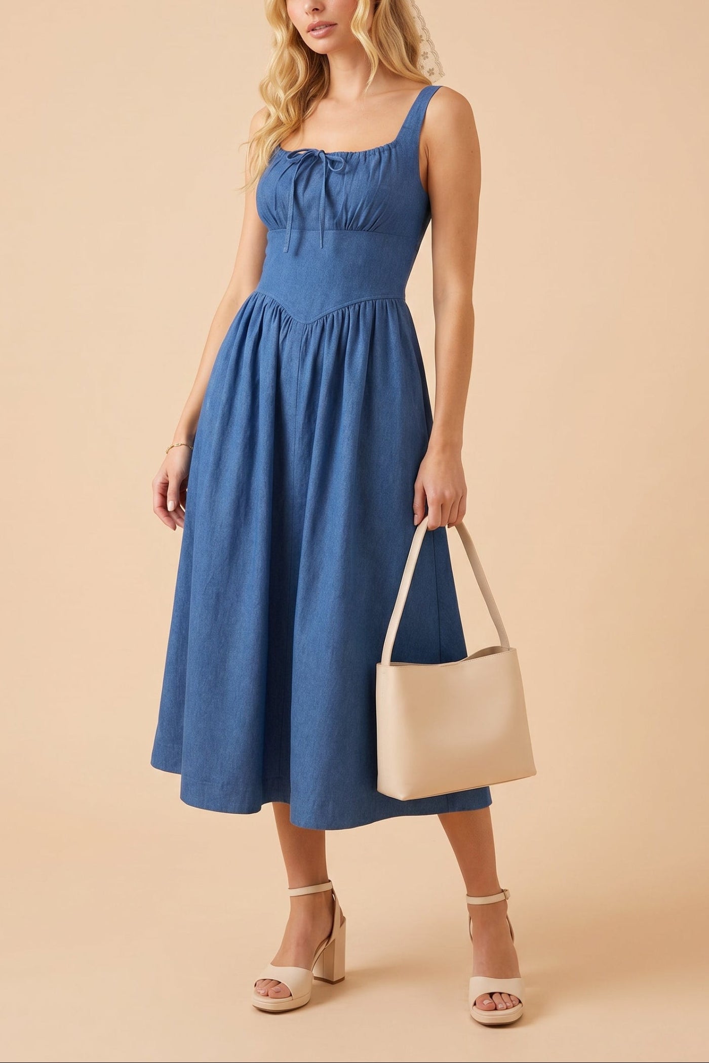 woman wearing Gerogene Blue Denim Midi Dress with Bow and pockets at boutique 1861
