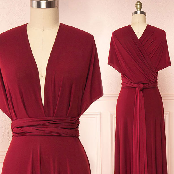 Red wrap dress on a mannequin against a light pink wall.