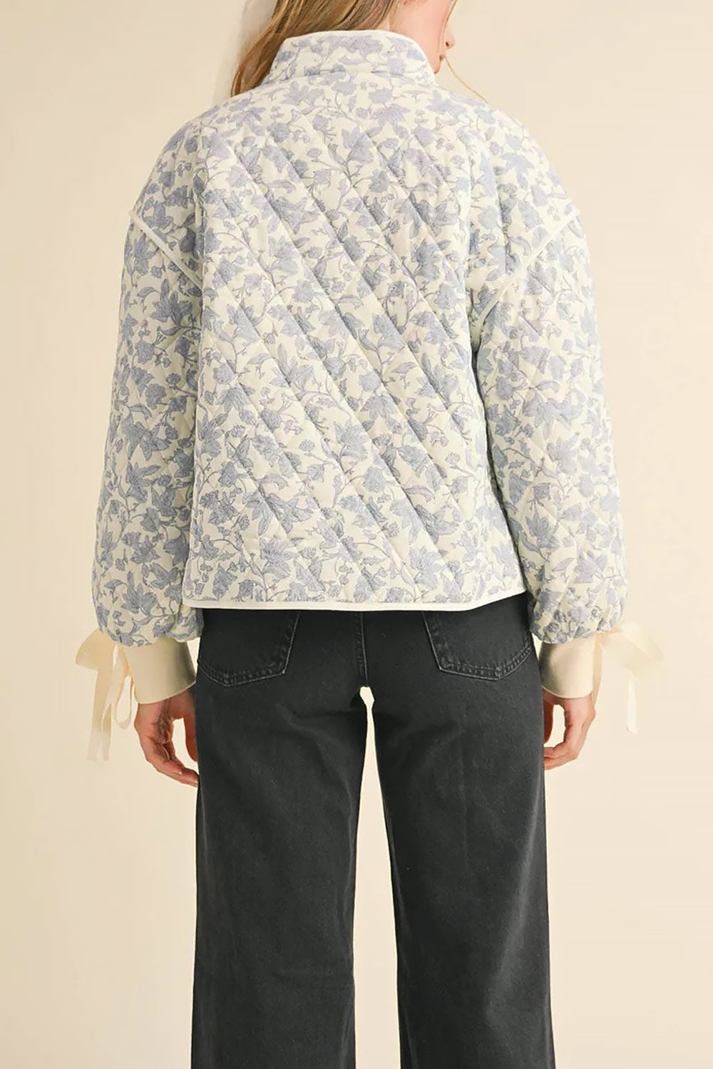back of a woman wearing Anabeth Blue Floral Quilted Jacket with Ribbon-Tied from Boutique 1861