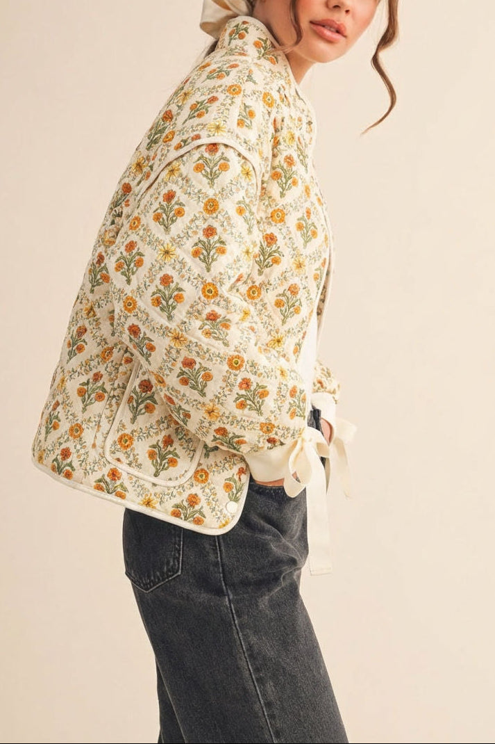 side view of a woman wearing Anabeth Orange Floral Quilted Jacket with Ribbon-Tied from Boutique 1861