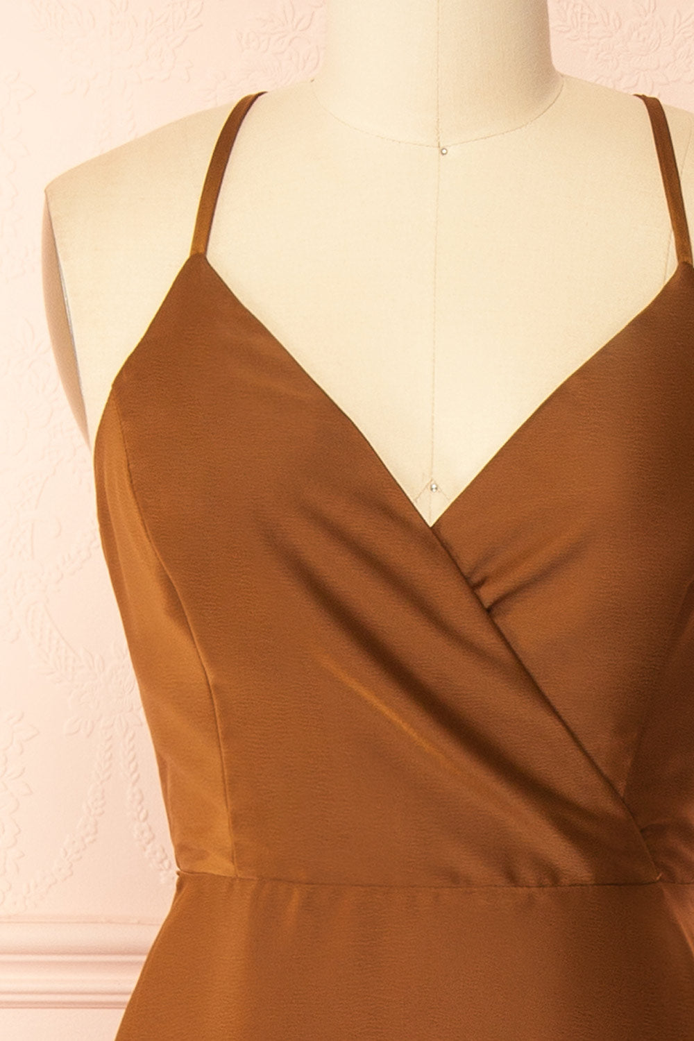 front of a mannequin wearing the Caryanne Brown Tie-Back Satin Dress from Boutique 1861