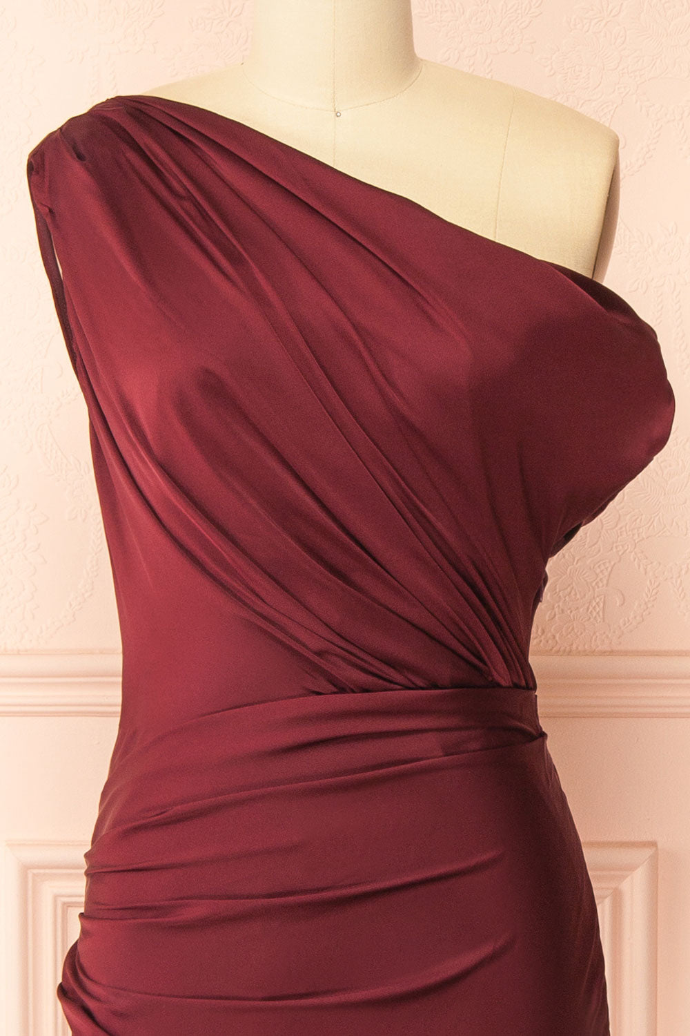 front of mannequin wearing Colleen Burgundy Asymmetrical Satin Dress from boutique 1861