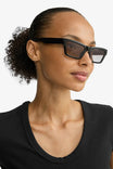side of a woman wearing Crema Black Rectangle Frame Sunglasses by Pilgrim from La petite garçonne