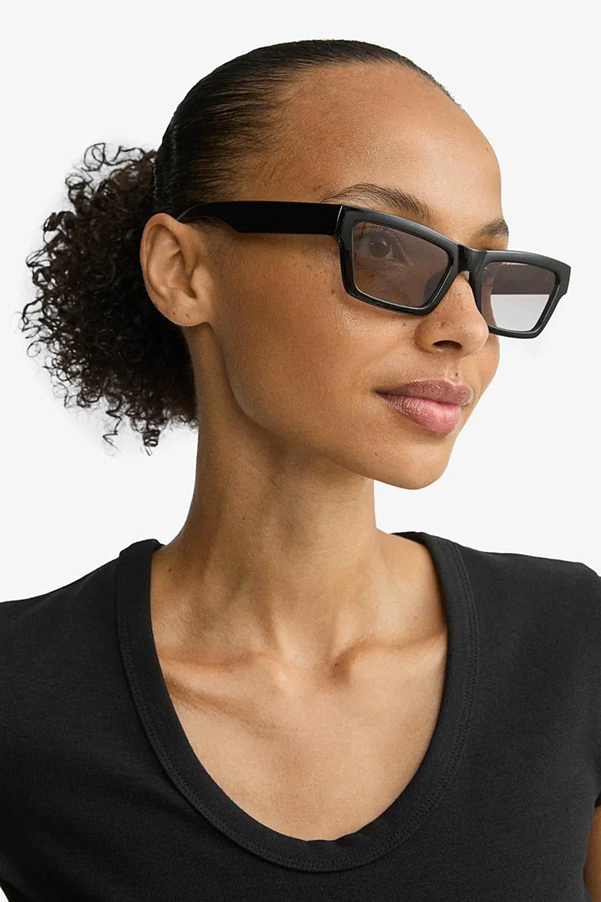 side of a woman wearing Crema Black Rectangle Frame Sunglasses by Pilgrim from La petite garçonne