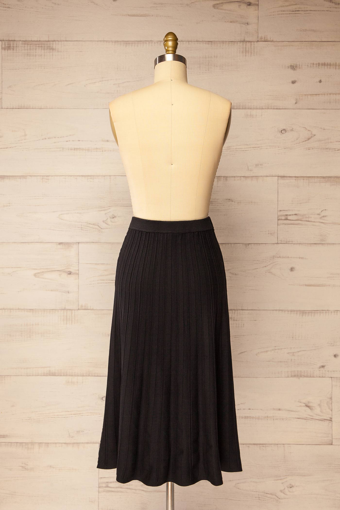 back view of Devonport Black High-Waisted Ribbed Knit Midi Skirt at La petite garçonne