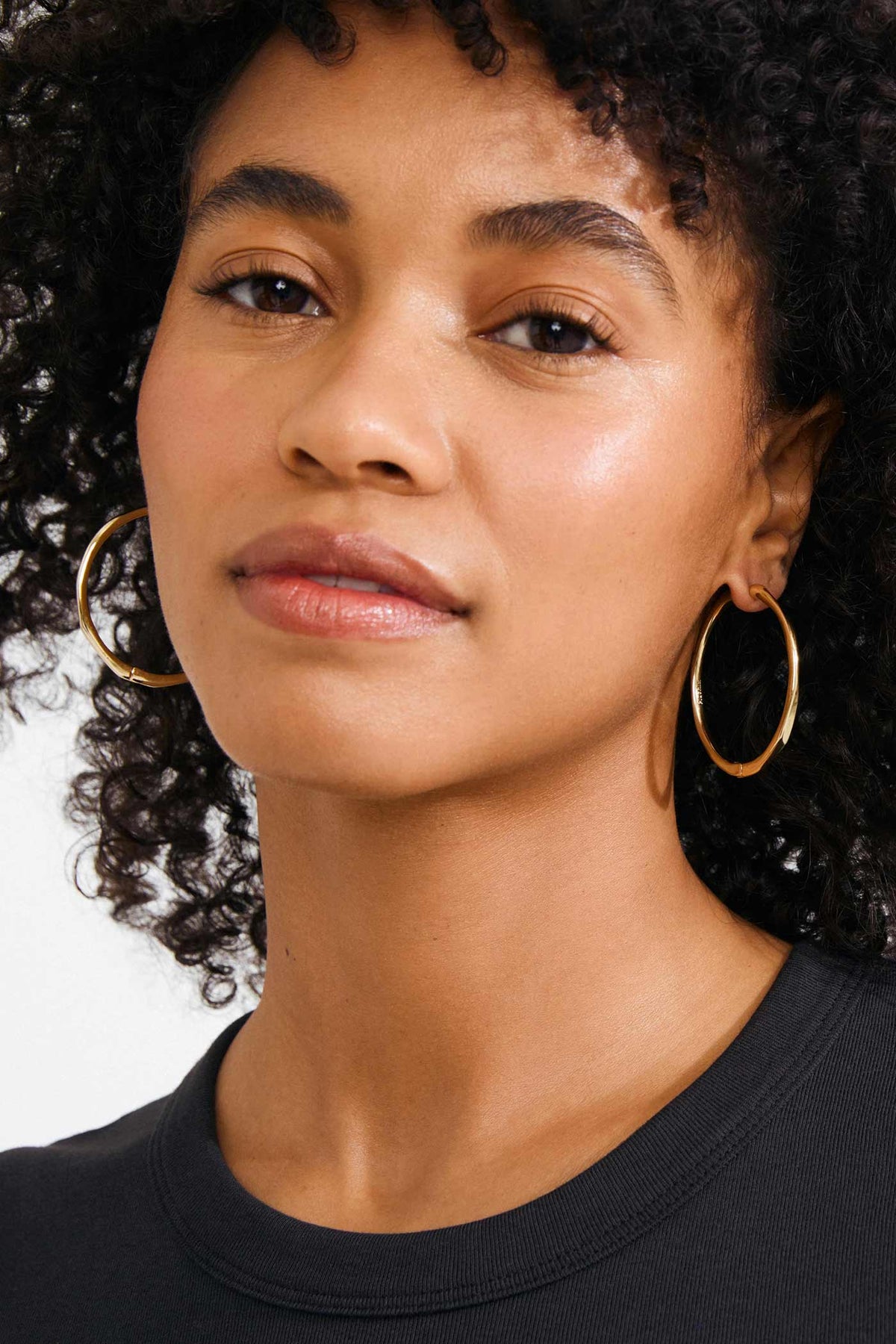 view of a woman wearing Edelia Gold Wave Hoop Earrings by Pilgrim from La petite garçonne
