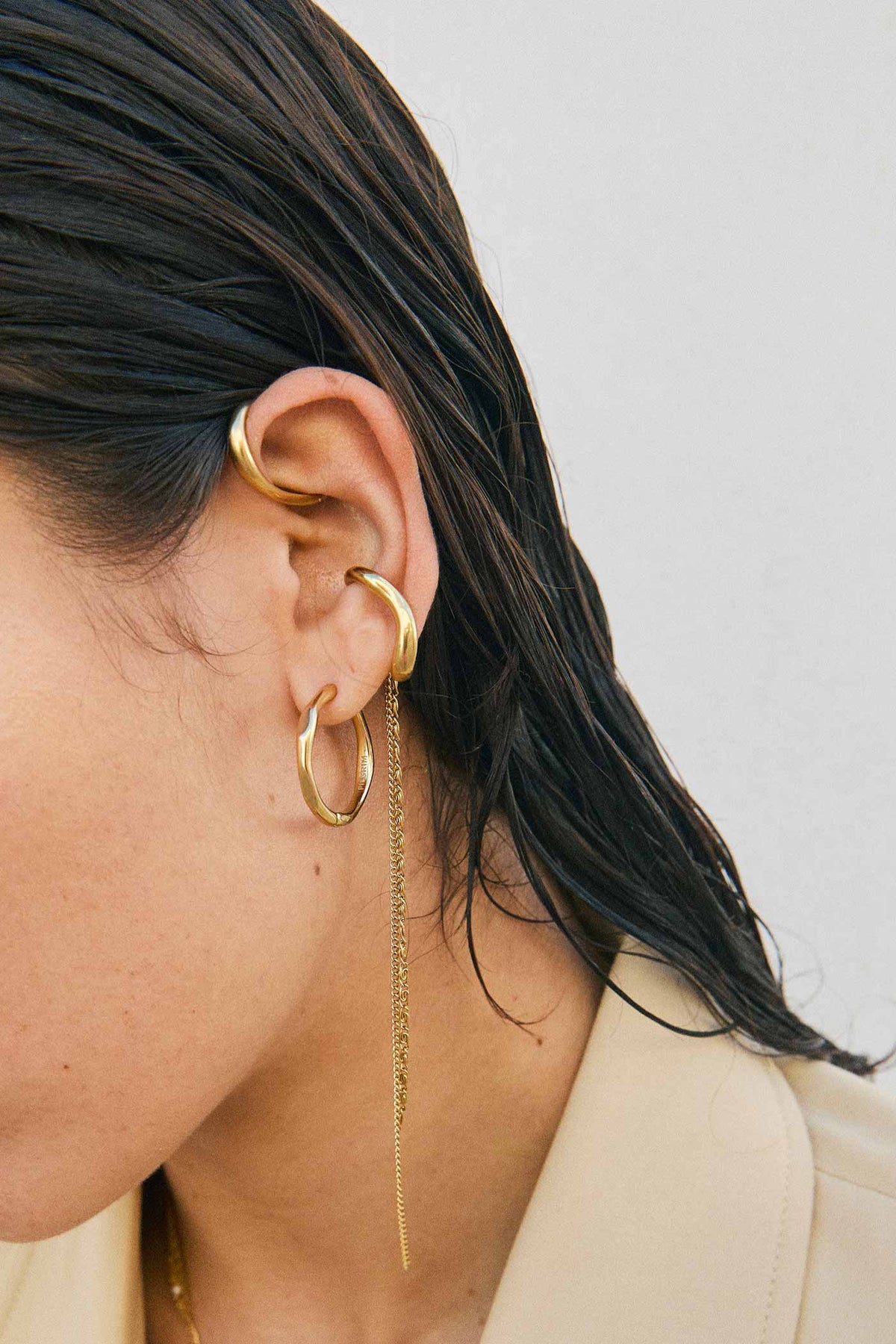 lifestyle shot of a woman wearing Eluda Gold Wave Hoop Earrings by Pilgrim from La petite garçonne