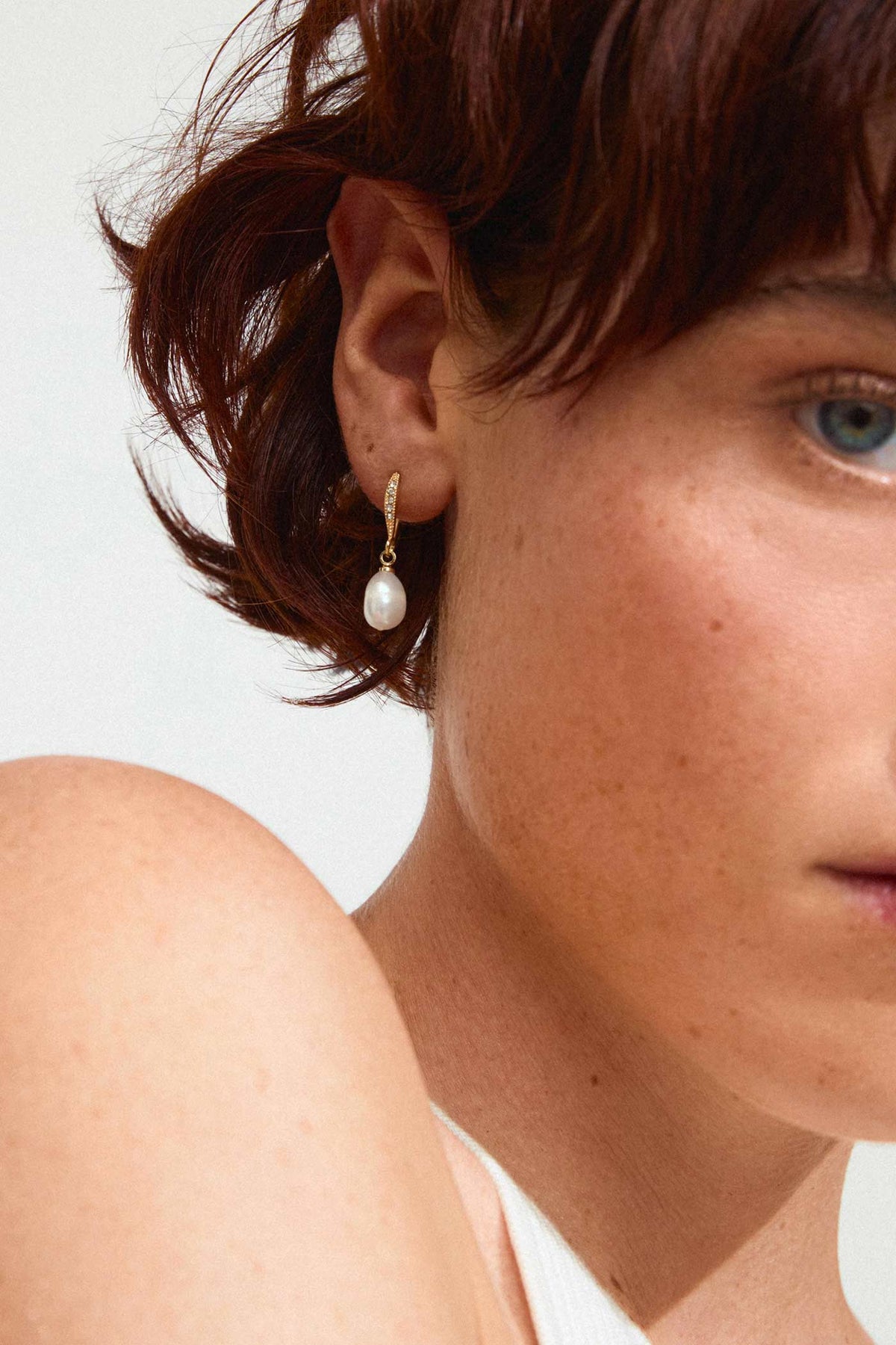 close-up of a woman wearing Florea Gold Pearl Drop Earrings with Crystals by Pilgrim from La petite garçonne