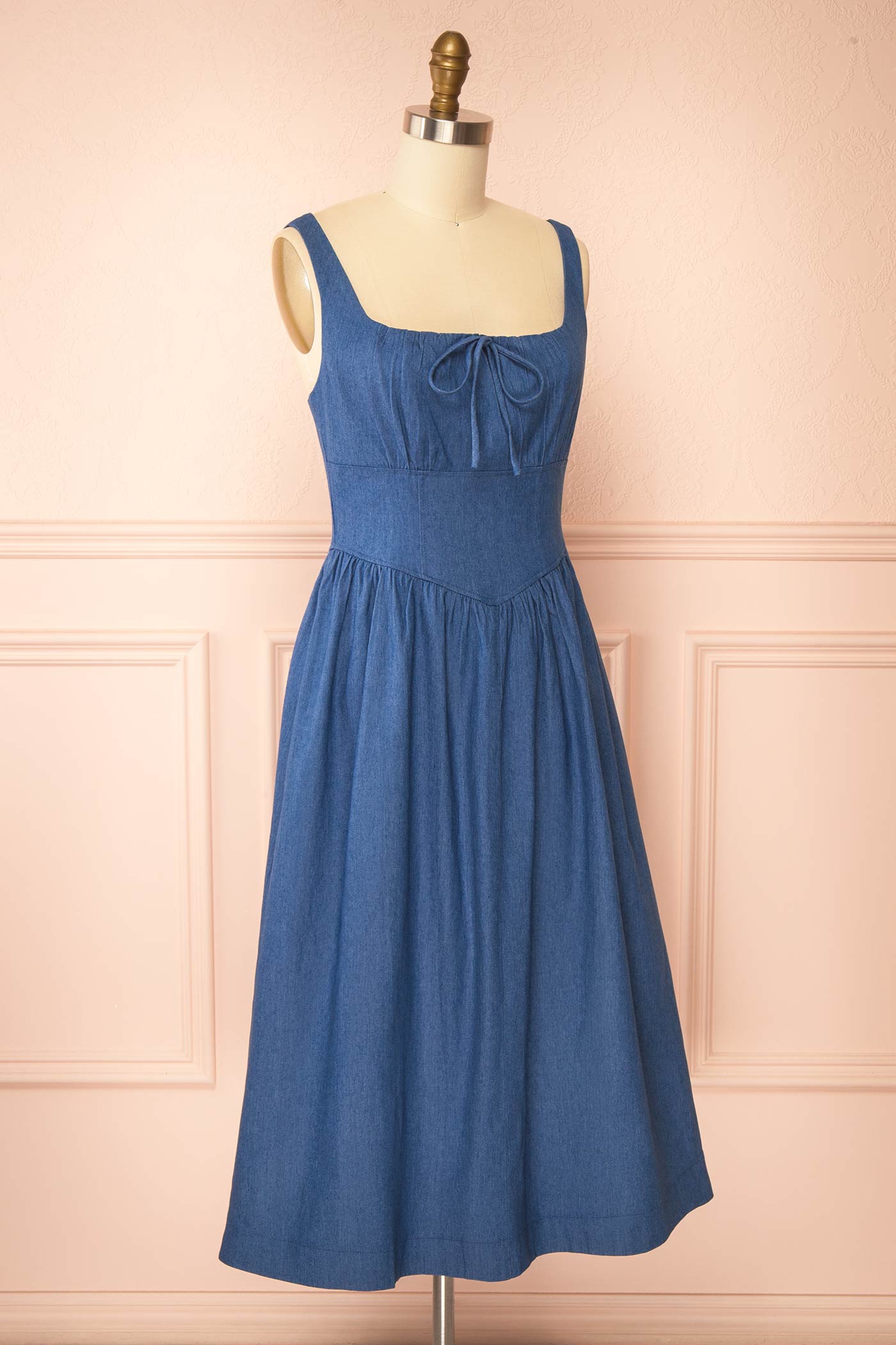 Sideview of Gerogene Blue Denim Midi Dress with Bow and Smocked Back at boutique 1861