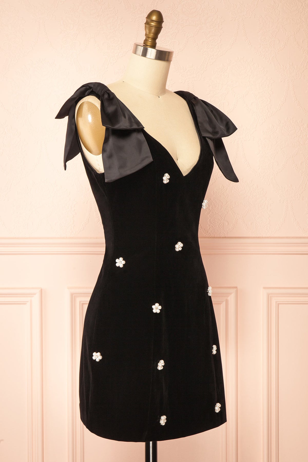 Side view of Geynneth Black Velvet Pearl Embellished Bow Shoulder Mini Dress at Boutique 1861