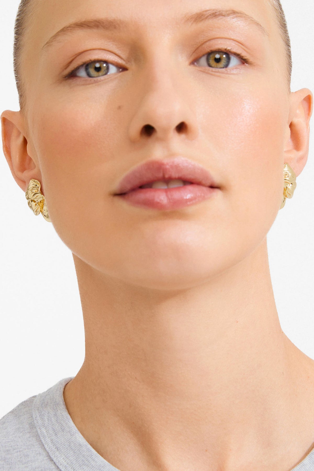 view of a woman wearing Halua Gold Large Petal Stud Earrings by Pilgrim from La petite garçonne