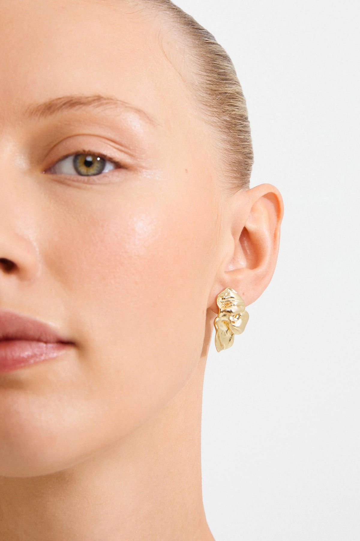 close-up of a woman wearing Halua Gold Large Petal Stud Earrings by Pilgrim from La petite garçonne