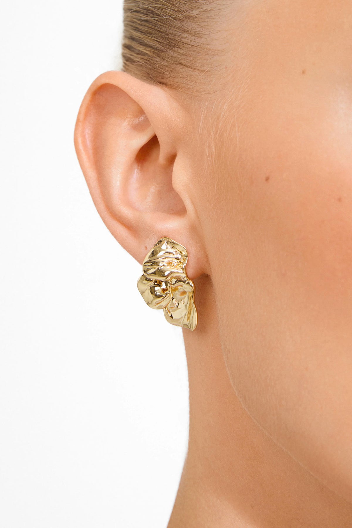 ear of a woman wearing Halua Gold Large Petal Stud Earrings by Pilgrim from La petite garçonne