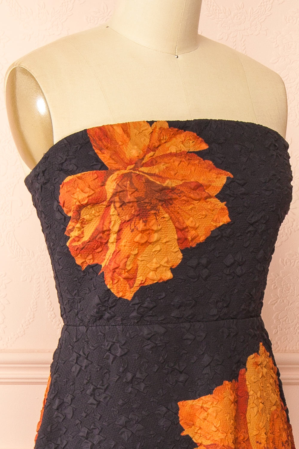 side of a Mannequin wearing the Kerina Midi Floral Strapless Dress from boutique 1861