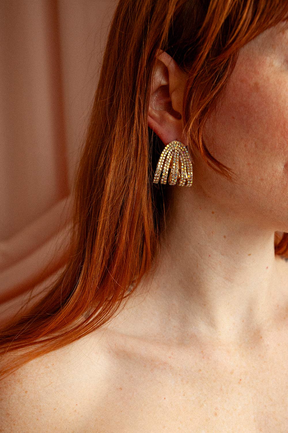 close-up of a woman wearing Moana Gold Iridescent Crystal Earrings from Boutique 1861