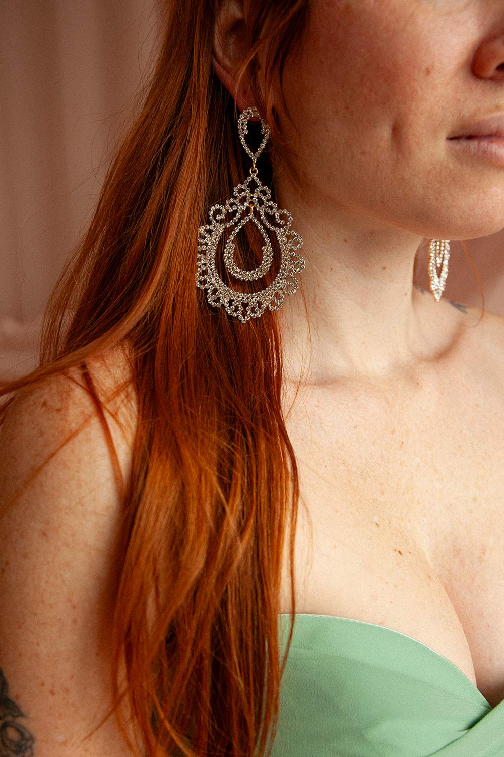 woman wearing gold rhinestone layered teardrop dangle earrings shimmer with intricate, lace-like sparkle from boutique 1861