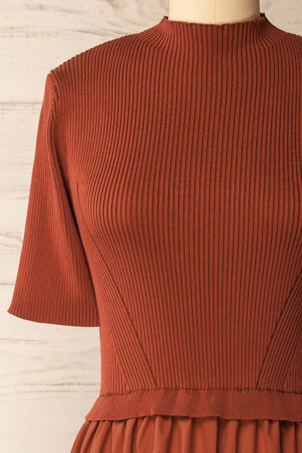 front of a mannequin wearing the Penrith Rust Mock Neck Midi Dress from boutique 1861