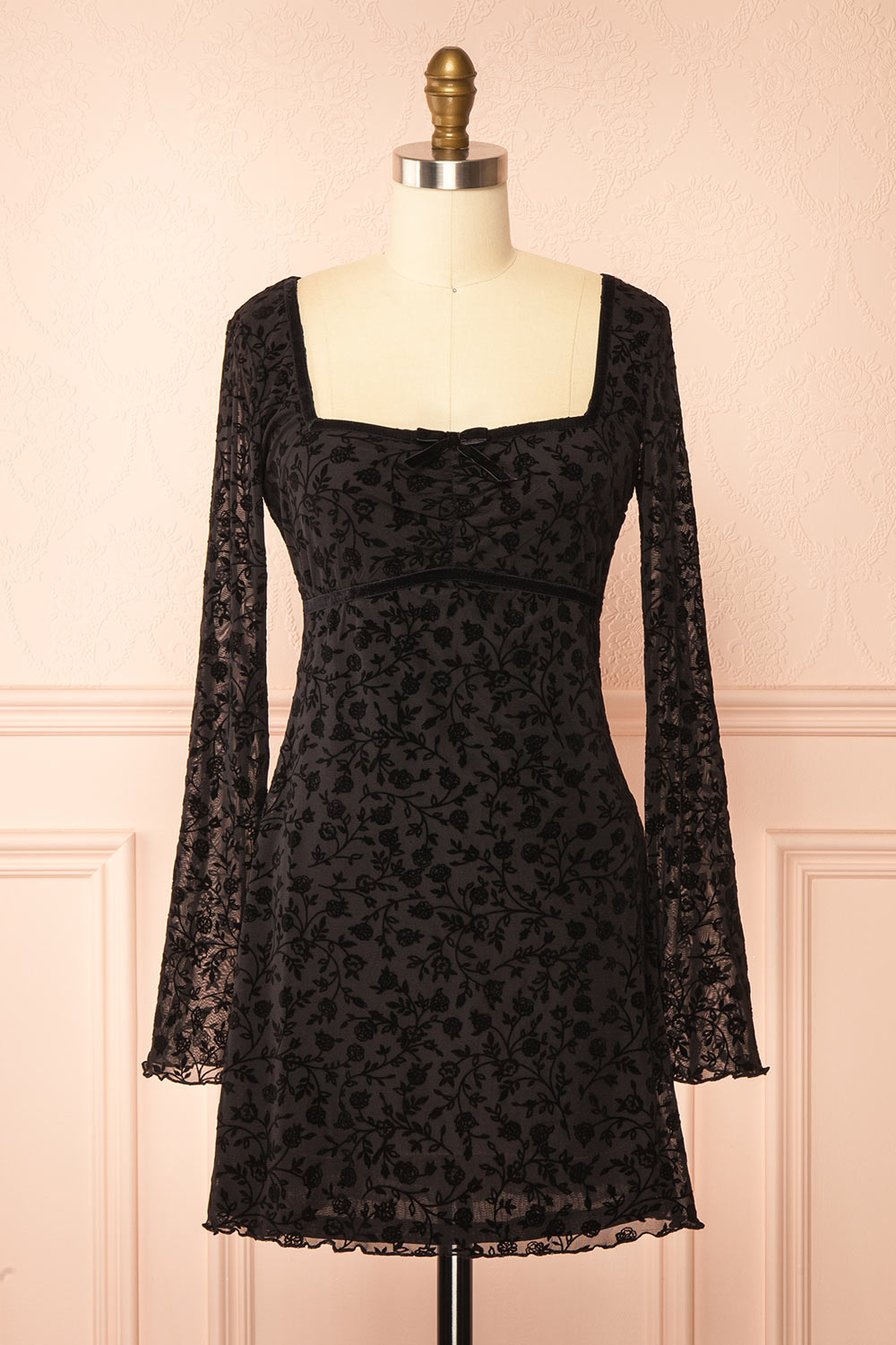 front of a mannequin wearing a Zoeline Short Long-Sleeved Black Dress from boutique 1861