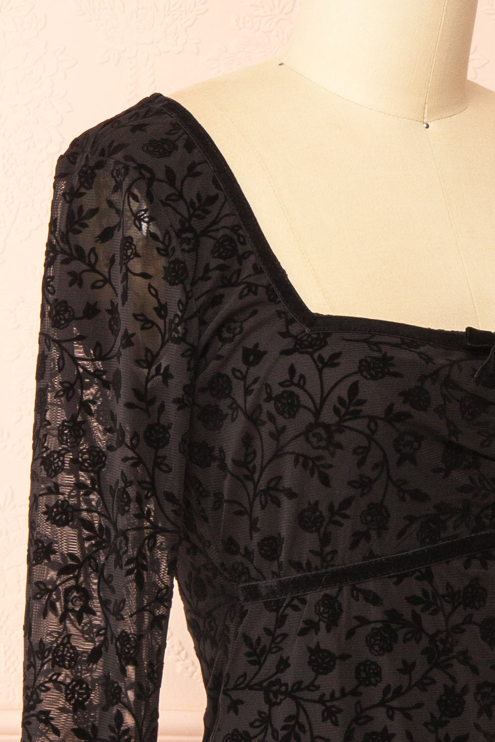 side of a mannequin wearing a Zoeline Short Long-Sleeved Black Dress from boutique 1861