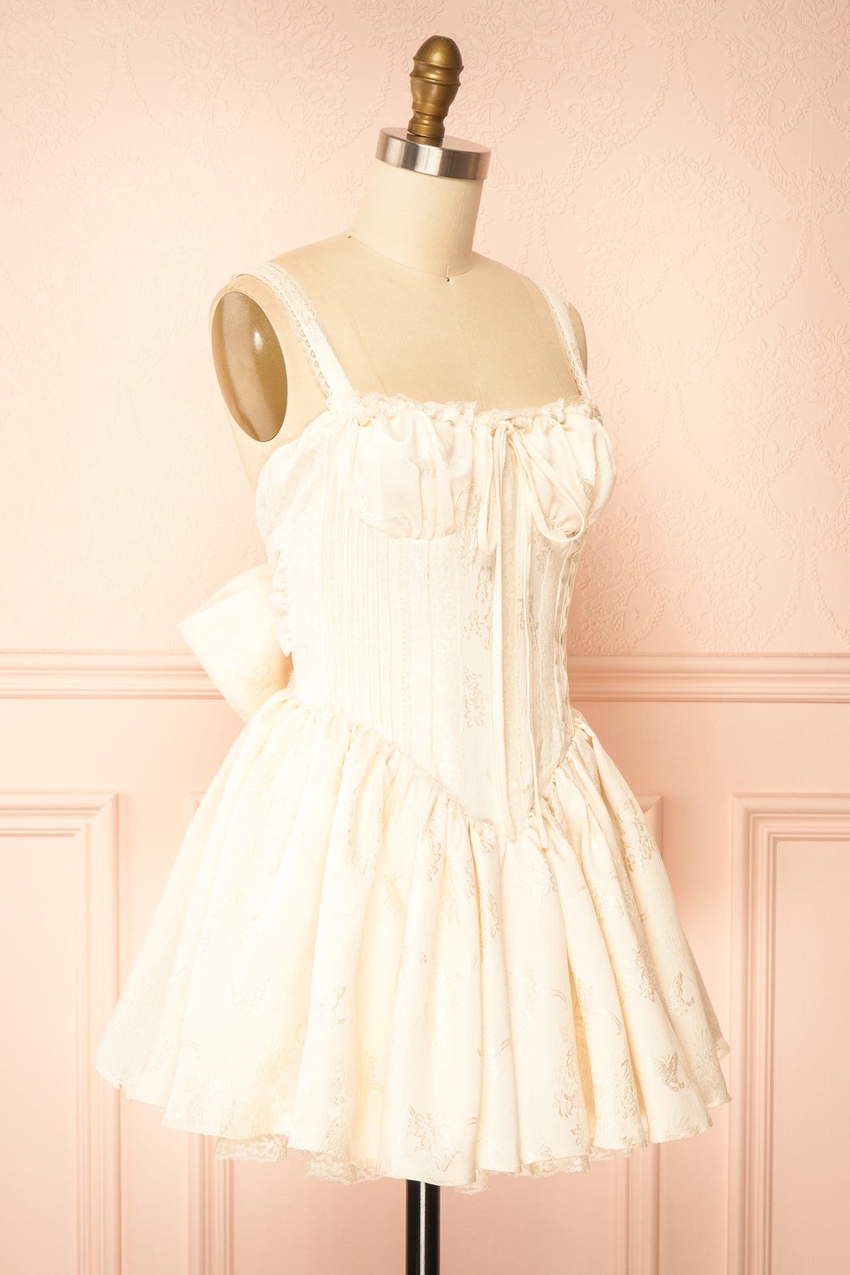 side view of Zolda Ivory Short Jacquard Corset Dress with Back Bow at Boutique 1861