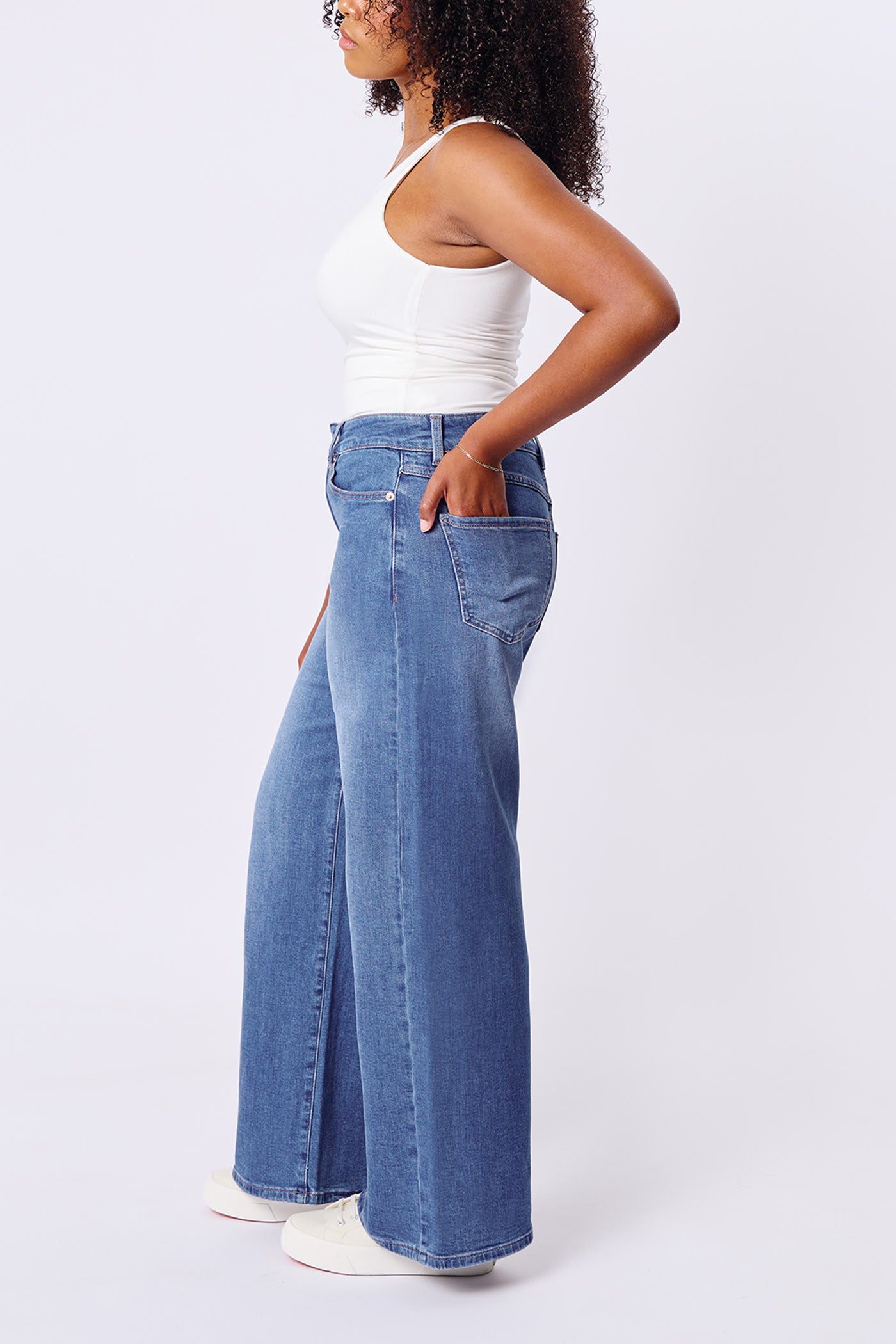 side of a medium size woman wearing Aurora Jeans Blue High-Waisted Wide-Leg Jeans by Dailystory from La petite garçonne